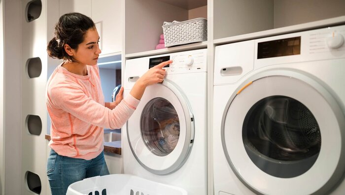 Frau spart Strom mit Waschmaschine