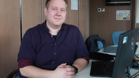 Dennis Henky sitzt am Schreibtisch