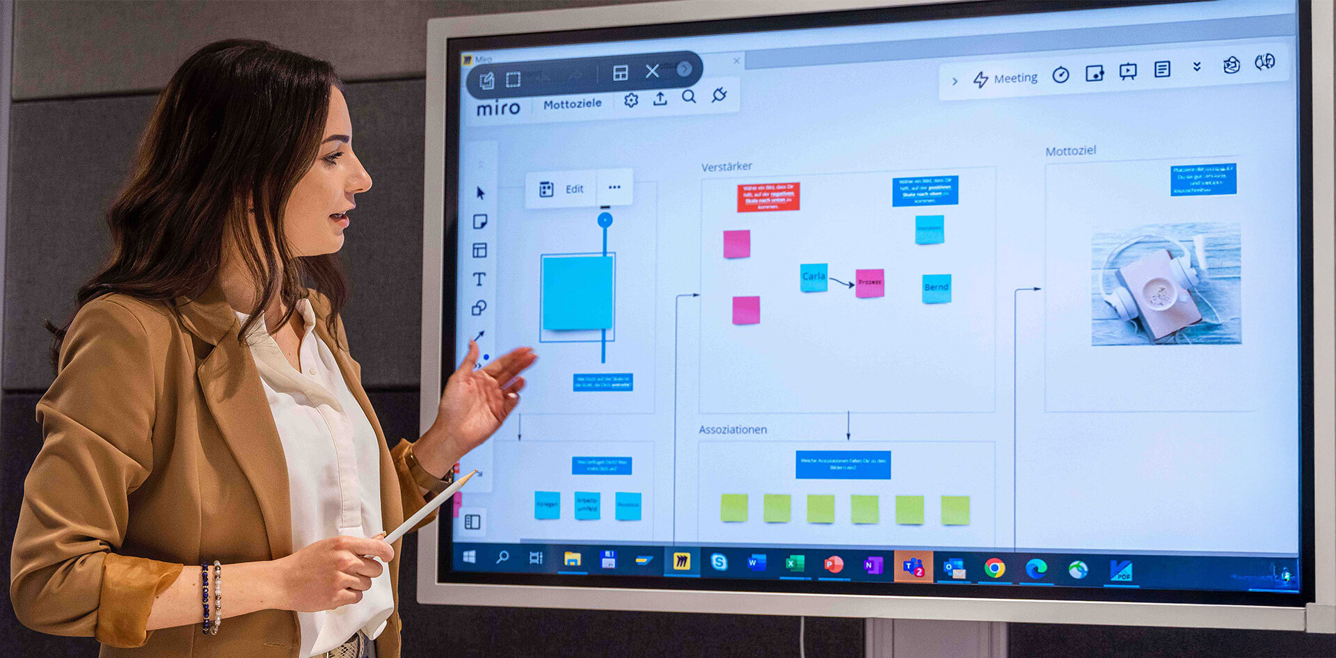 Mitarbeiterin präsentiert Inhalte auf einem digitalen Whiteboard