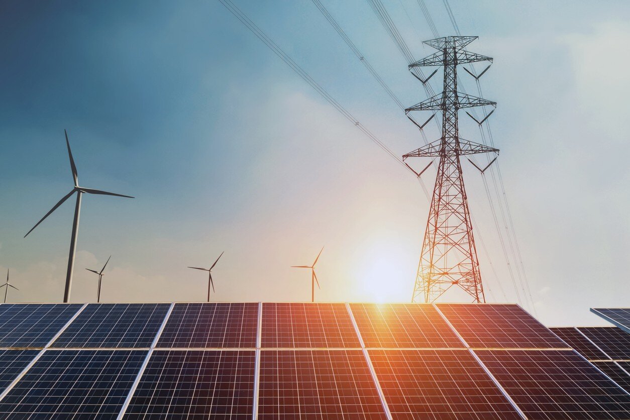 Solarzellen, Strommast und Windräder, Sonnenuntergang im Hintergrund 