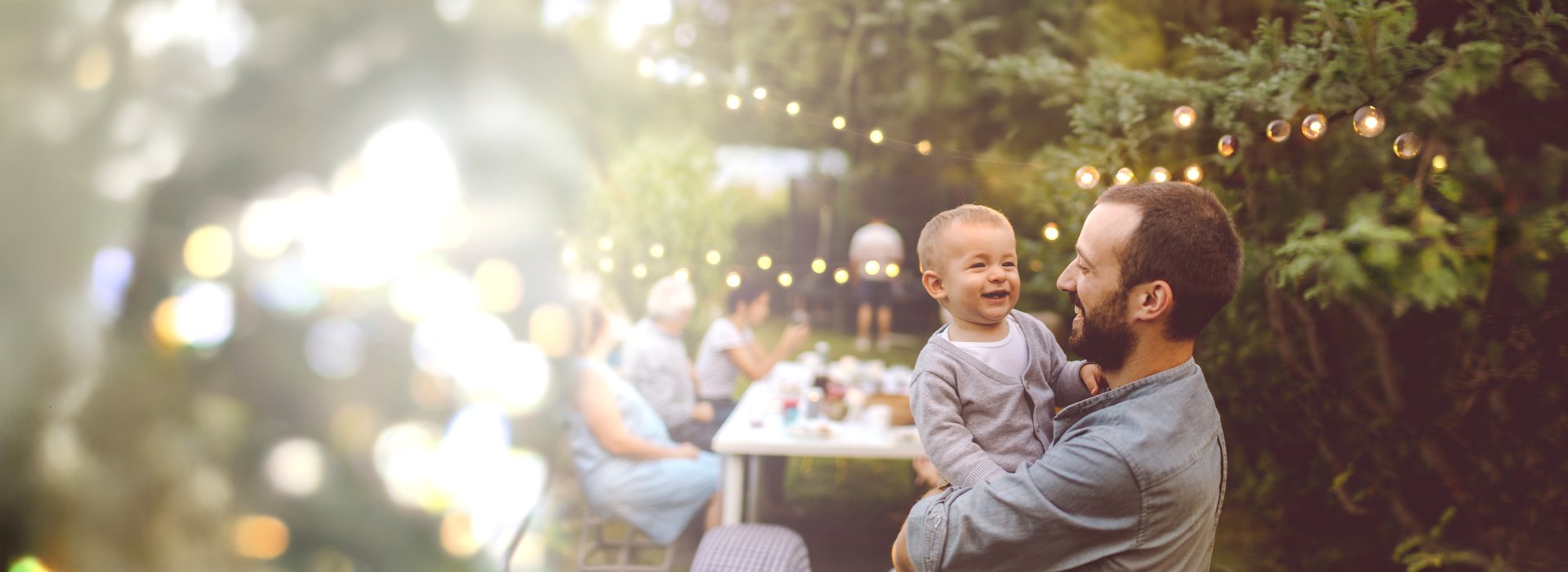 Mann mit Baby auf Arm in Garten