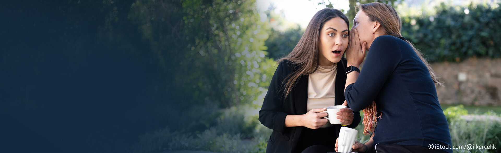Frauen flüstern sich etwas ins Ohr
