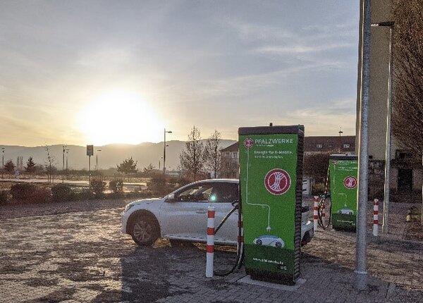 E-Auto an Ladesäule bei Sonnenuntergang