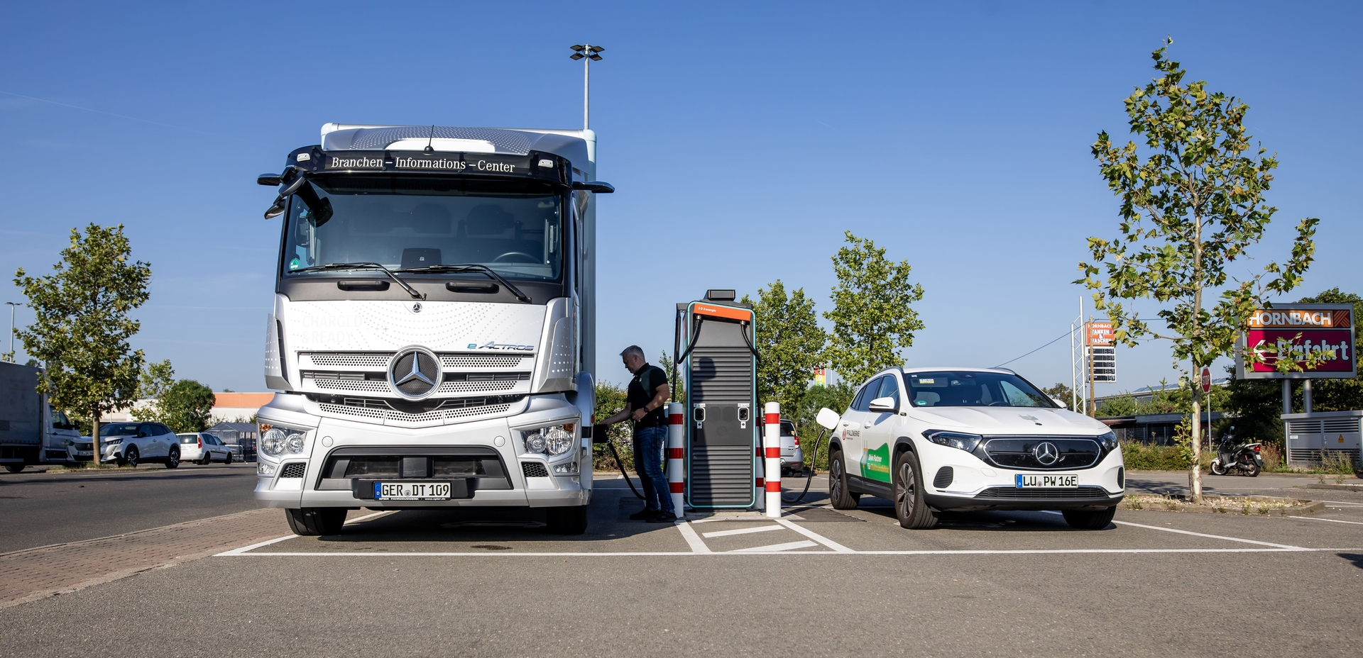 Elektrischer Lkw und Elektroauto laden an einer öffentlicher Schnellladestation der Pfalzwerke am Standort von Hornbach in Bornheim