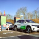 Elektrisches Auto lädt an öffentlicher Schnellladestation auf Parkplatz vom Baumarkt Hornbach