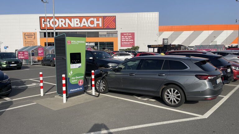 Elektroauto lädt an Pfalzwerke‑Schnellladestation auf Kundenparkplatz vor Hornbach Baumarkt in Paderborn
