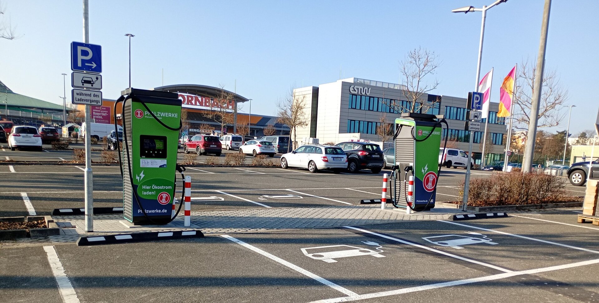 Elektrofahrzeuge laden an Schnellladestationen auf Kundenparkplatz des Hornbach‑Standorts in Erlangen