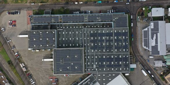 Das Bild zeigt eine Luftaufnahme einer PV-Anlage auf einem Gebäudedach.