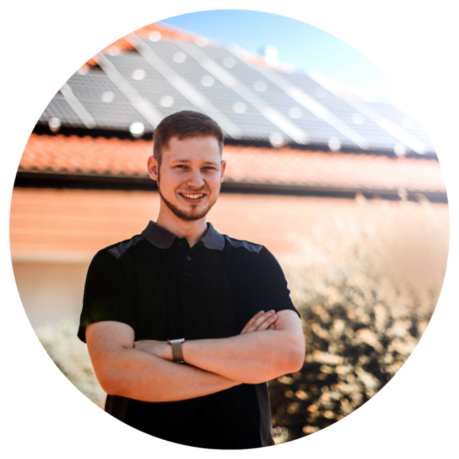 Solar-Experte der PFALZWERKE vor einem Haus mit Solaranlage auf dem Dach