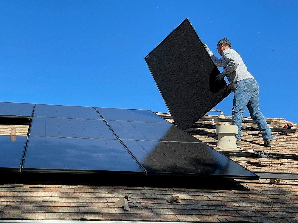 Solarmonteur steht auf dem Dach und befestigt eine Solaranlage