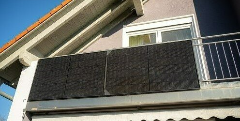 Das Bild zeigt eine Mini-PV-Anlage an einem Balkongeländer. 