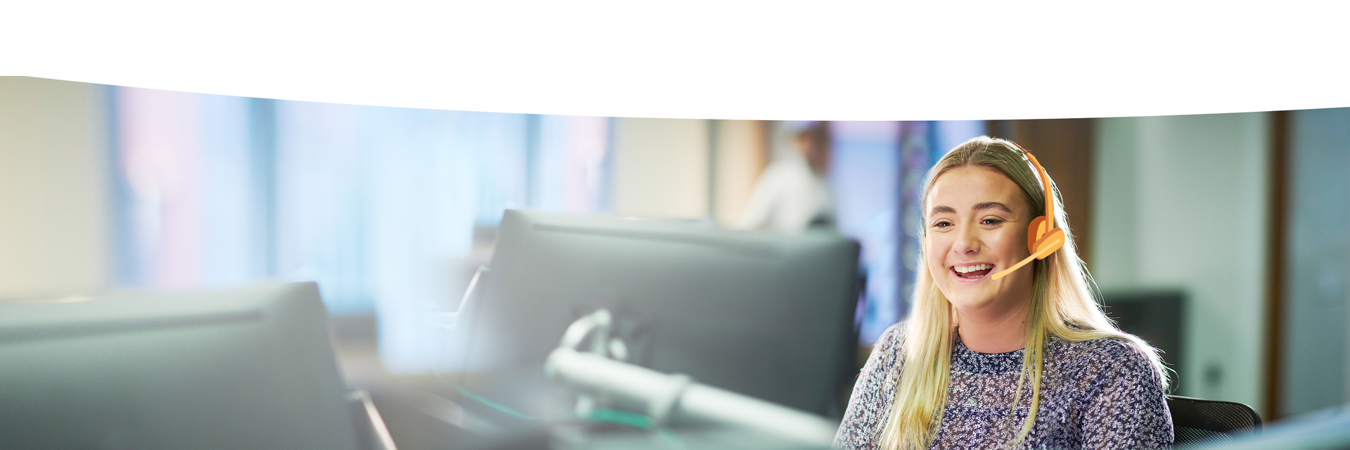 laechelnde Angestellte beim Telefonieren