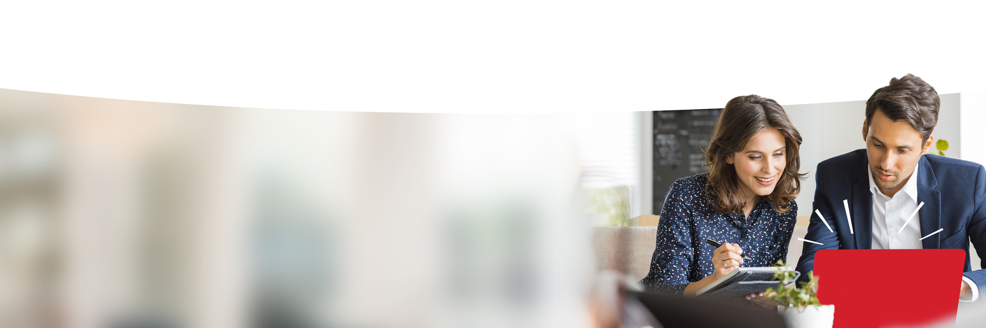 Zwei Erwachsene schauen auf einen Laptop.