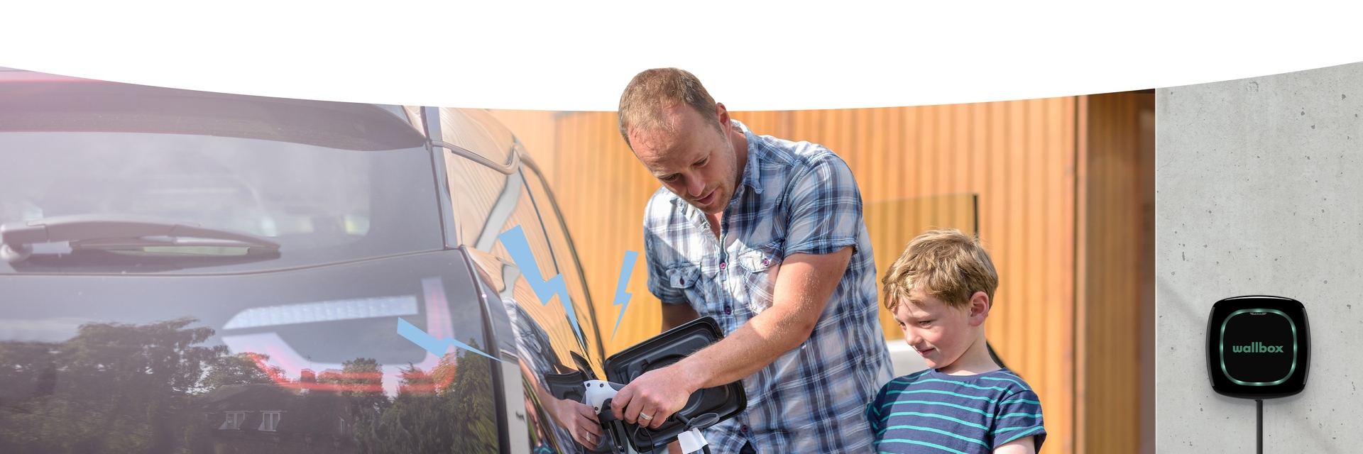 Das Bild zeigt einen Mann mit  einem Kind, die ein Elektroauto an einer Ladestation laden. 