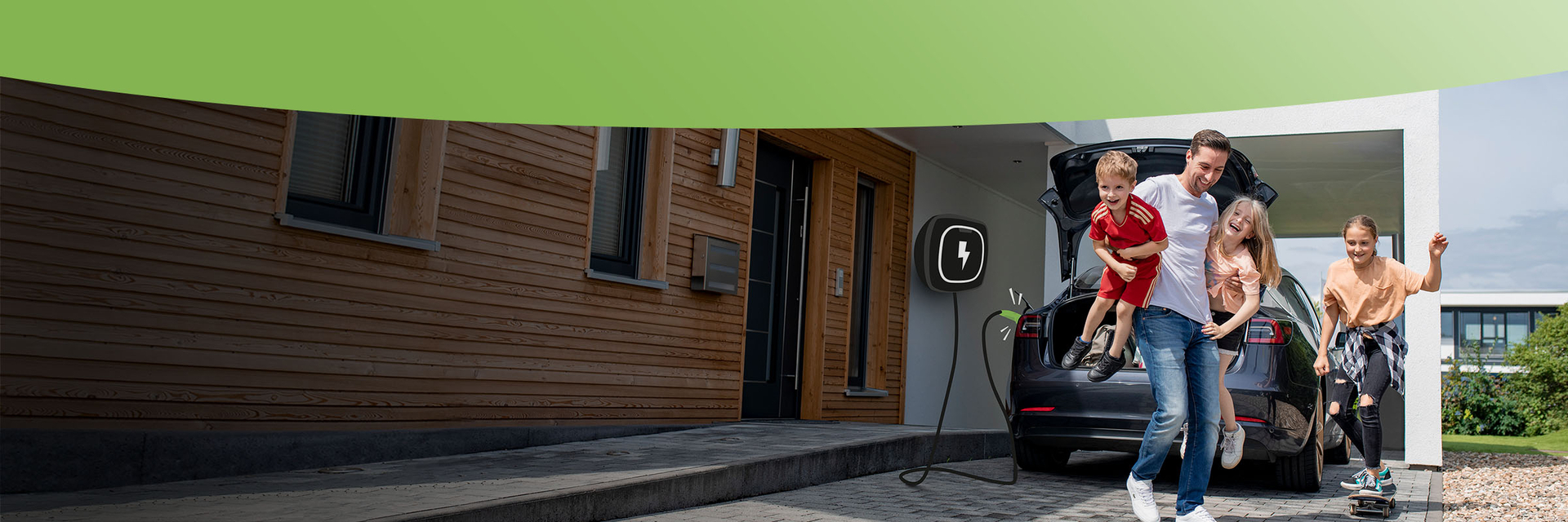 Glückliche Familie am E-Auto