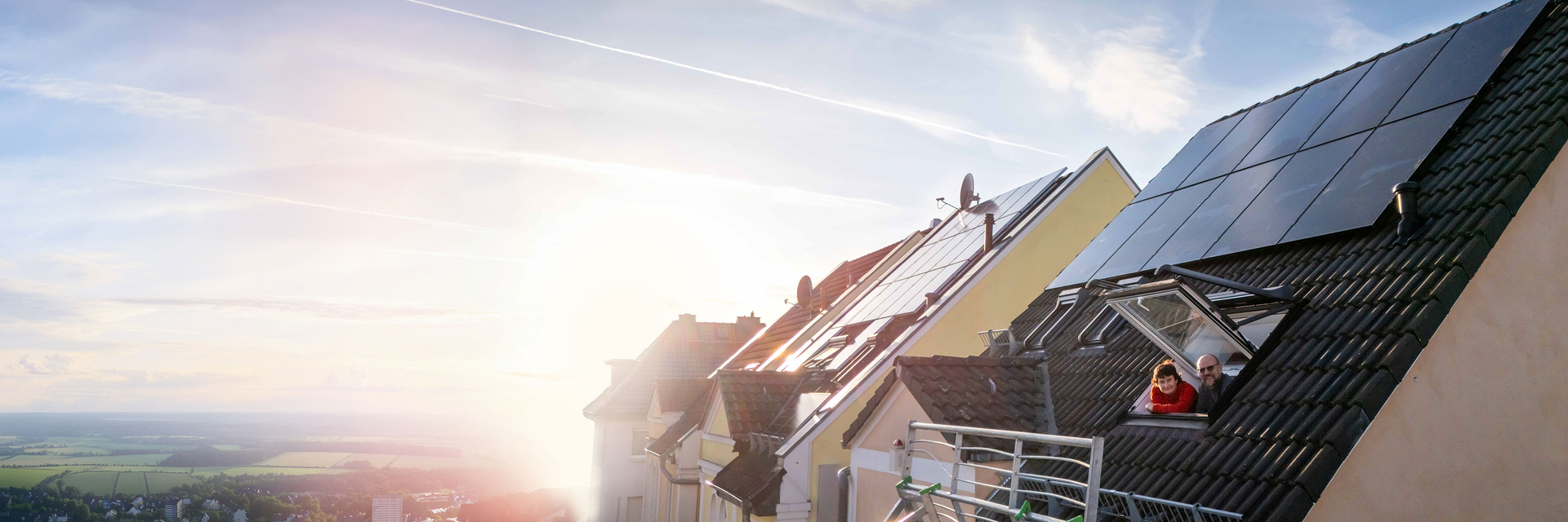 Ehepaar schaut aus dem Dachfenster mit Photovoltaikanlage | © Bildnachweis: Pfalzwerke/Marc Wilhelm