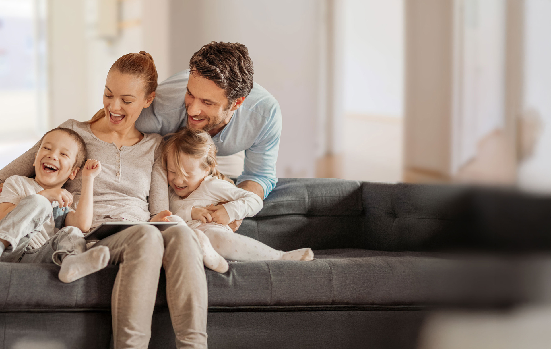 Familie auf der Couch mit Tablet
