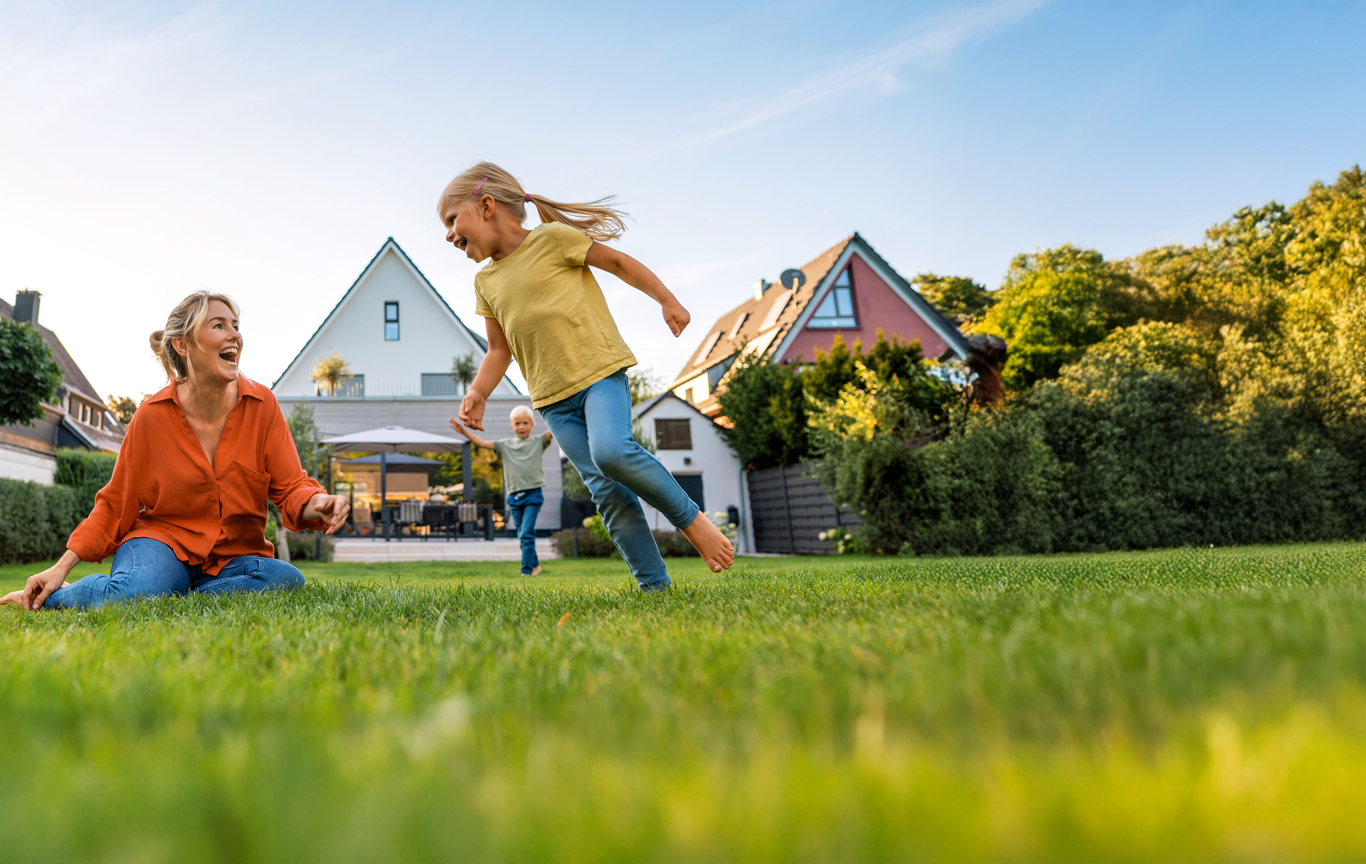 Junge Familie im Garten vorm eigenen Zuhause | © Bildnachweis: GettyImages, Westend61 / Joseffson