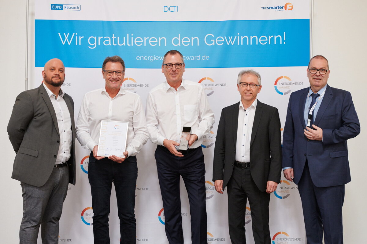 Fünf Männer blicken in die Kamera und zeigen den Energiewende Award.