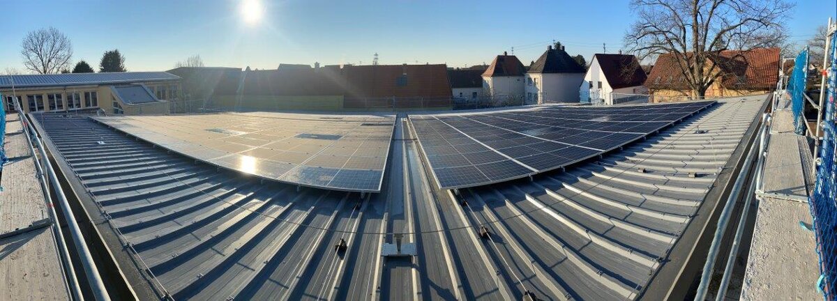 Das Bild zeigt eine Solaranlage auf dem Dach eines Gebäudes. 