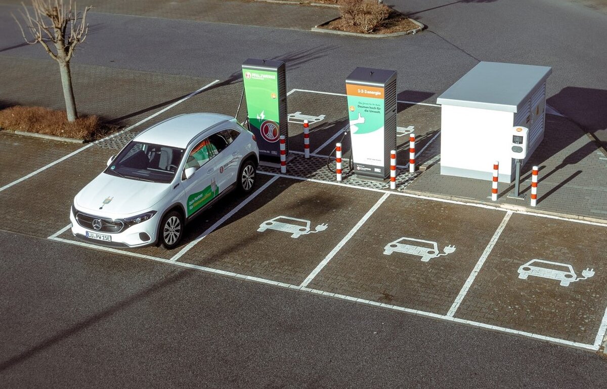 Das Bild zeigt ein Auto an einer Ladesäule aus der Vogelperspektive. 