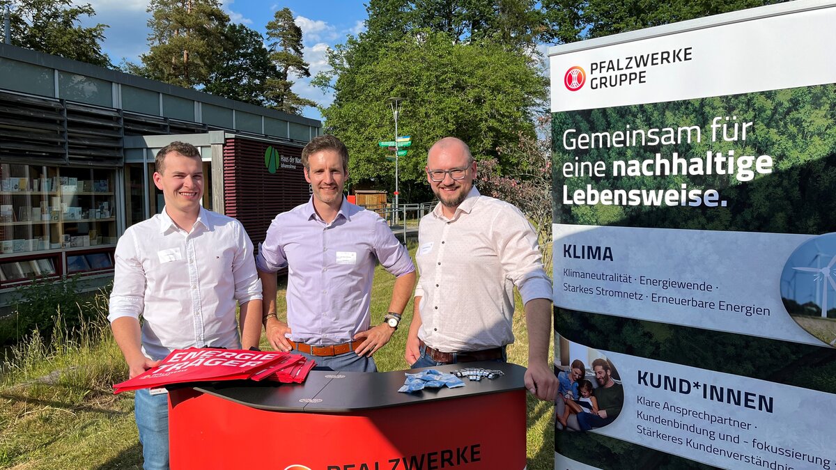 Drei Männer stehen an einem Stand der Pfalzwerke.