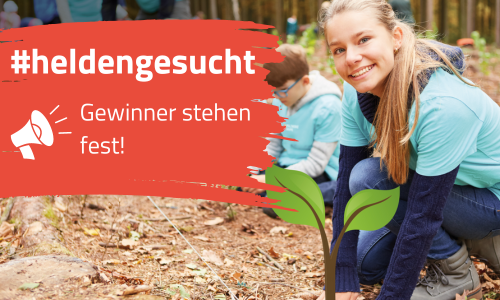 Eine junge Frau pflanzt etwas in den Boden ein und lächelt in die Kamera.