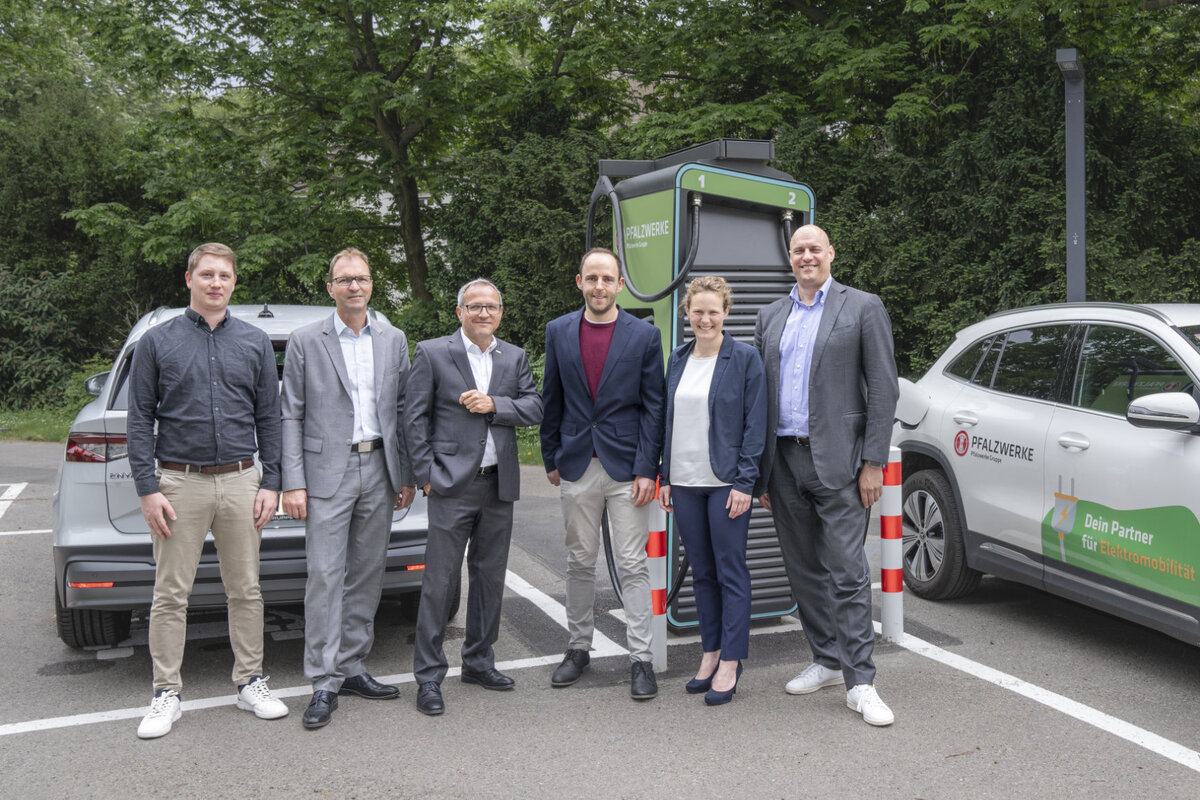 Sechs Menschen stehen vor der Ladesäule im Ladepark BASF