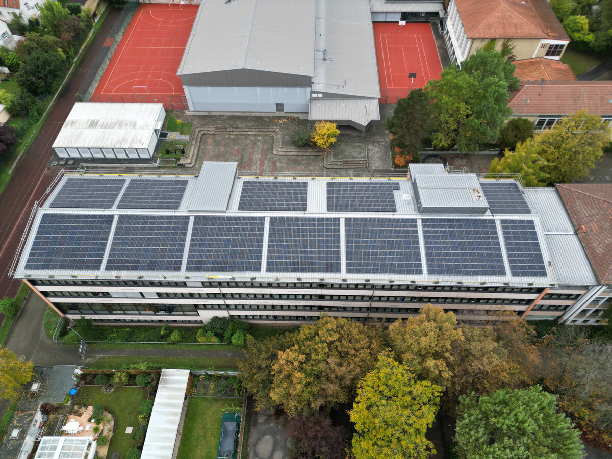 Drohnenbild einer Solaranlage auf einem Gebäudedach. 