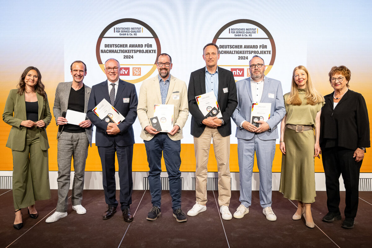 Das Bild zeigt eine Gruppe von Menschen bei der Preisverleihung des deutschen Award für Nachhaltigkeitsprojekte.