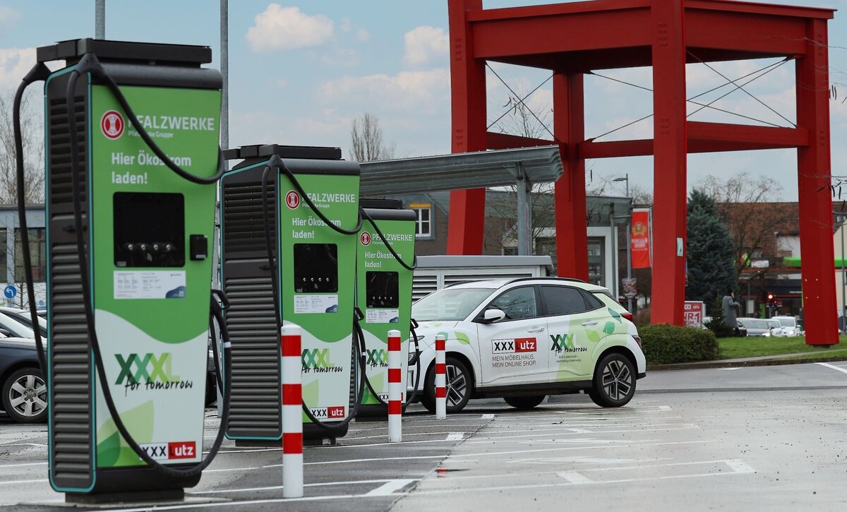 Das Bild zeigt drei Ladesäulen auf dem Parkplatz von XXXLutz in Würzburg.