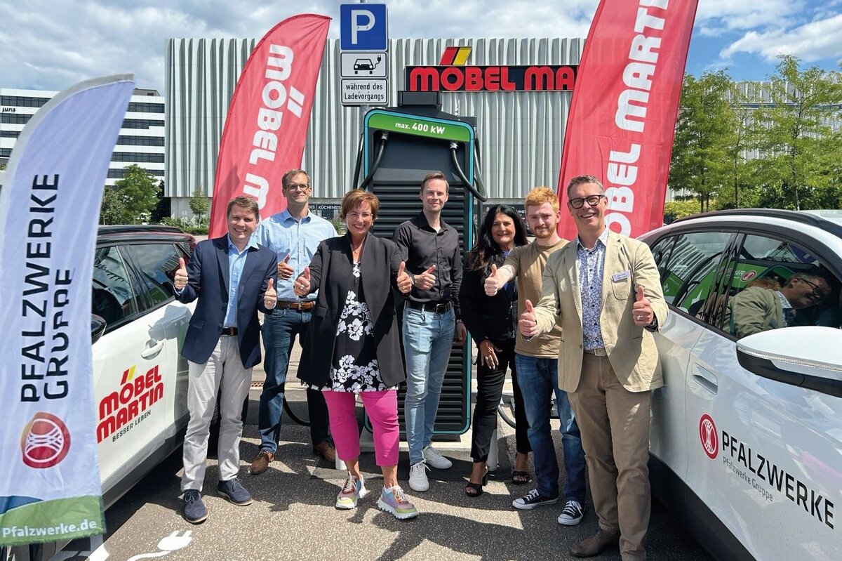 Vertreter und Vertreterinnen der Unternehmen Pfalzwerke und Möbel Martin freuen sich über die Eröffnung des Ladparks in Saarbrücken