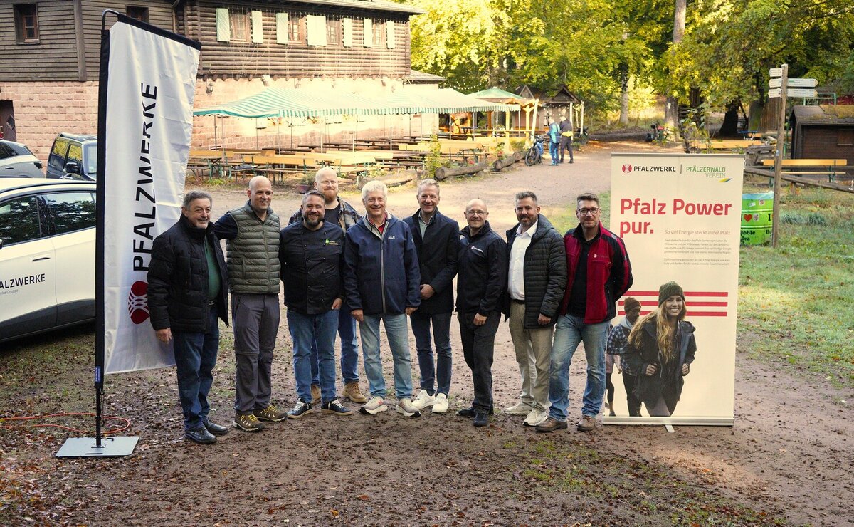 Gruppenbild von Vertreterinnen und Vertretern der Pfalzwerke und des Pfälzerwald-Vereins vor dem Waldhaus im Pfälzerwald.