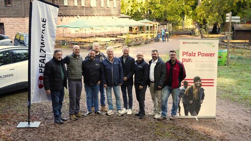 Gruppenbild von Vertreterinnen und Vertretern der Pfalzwerke und des Pfälzerwald-Vereins vor dem Waldhaus im Pfälzerwald.